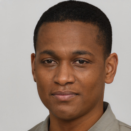Joyful black young-adult male with short  black hair and brown eyes