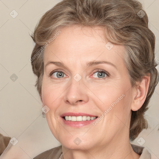 Joyful white adult female with medium  brown hair and grey eyes