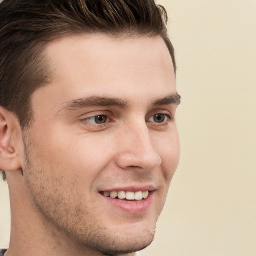 Joyful white young-adult male with short  brown hair and grey eyes