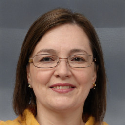 Joyful white adult female with medium  brown hair and blue eyes