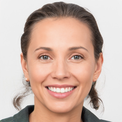 Joyful white adult female with medium  brown hair and grey eyes