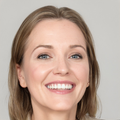 Joyful white adult female with medium  brown hair and blue eyes