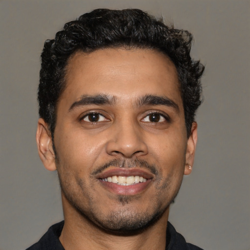 Joyful latino young-adult male with short  black hair and brown eyes