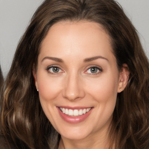 Joyful white young-adult female with long  brown hair and brown eyes