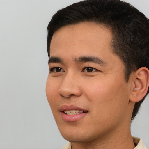 Joyful asian young-adult male with short  black hair and brown eyes