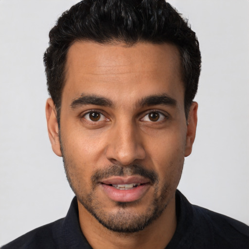 Joyful latino young-adult male with short  black hair and brown eyes