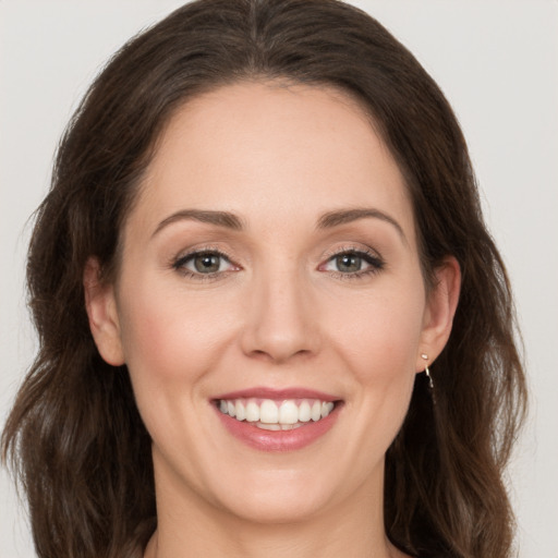 Joyful white young-adult female with long  brown hair and grey eyes