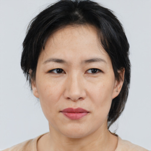 Joyful asian adult female with medium  brown hair and brown eyes