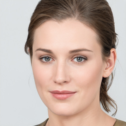 Joyful white young-adult female with medium  brown hair and grey eyes