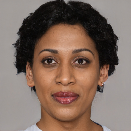 Joyful black young-adult female with short  black hair and brown eyes