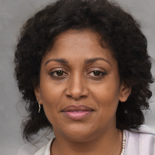 Joyful black adult female with medium  brown hair and brown eyes