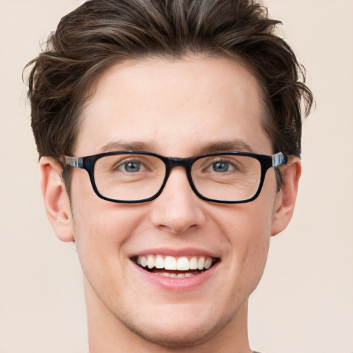 Joyful white young-adult male with short  brown hair and green eyes