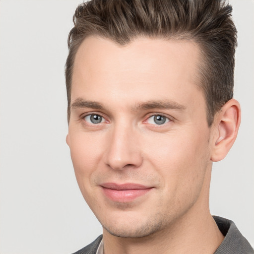 Joyful white young-adult male with short  brown hair and grey eyes