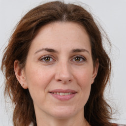 Joyful white adult female with medium  brown hair and green eyes