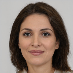 Joyful white adult female with medium  brown hair and brown eyes