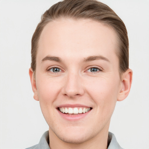 Joyful white young-adult male with short  brown hair and grey eyes