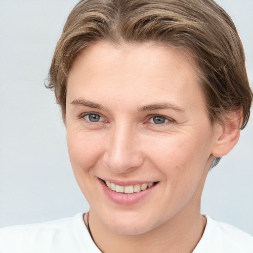 Joyful white young-adult female with short  brown hair and grey eyes