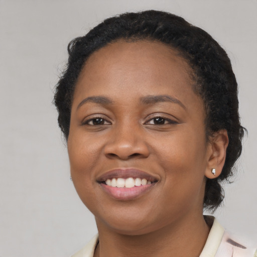 Joyful black young-adult female with long  black hair and brown eyes