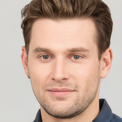 Joyful white young-adult male with short  brown hair and grey eyes