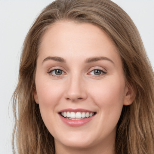 Joyful white young-adult female with long  brown hair and grey eyes