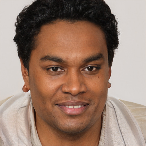 Joyful black young-adult male with short  brown hair and brown eyes