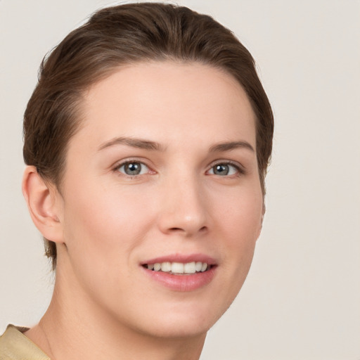 Joyful white young-adult female with short  brown hair and grey eyes