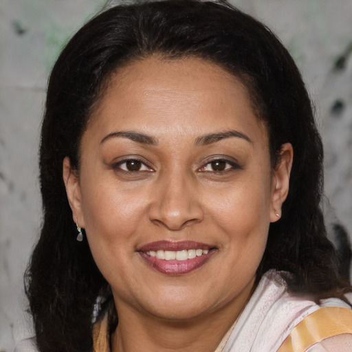 Joyful latino adult female with medium  brown hair and brown eyes