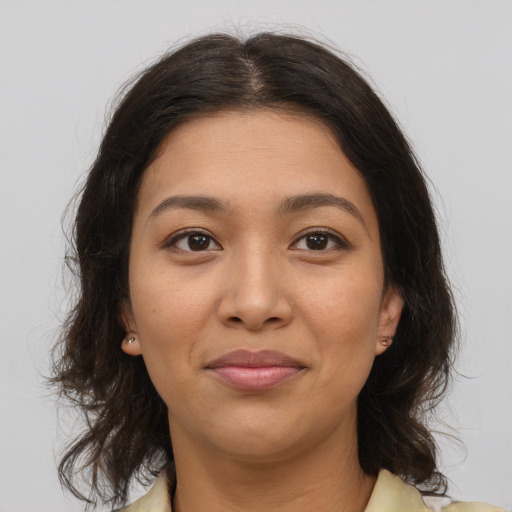Joyful latino young-adult female with medium  brown hair and brown eyes