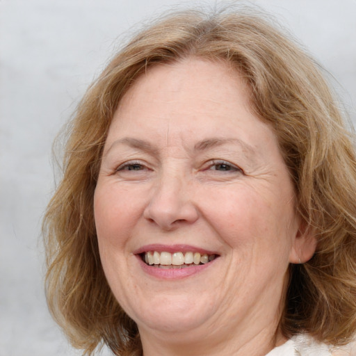 Joyful white middle-aged female with medium  brown hair and blue eyes