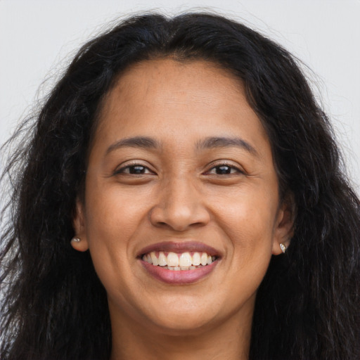 Joyful latino adult female with long  brown hair and brown eyes