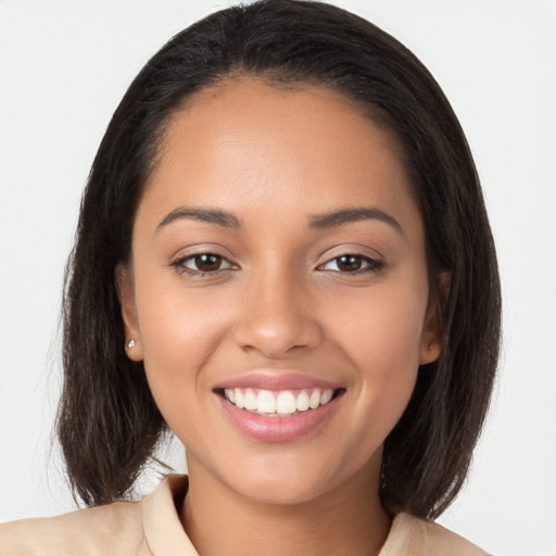 Joyful latino young-adult female with long  brown hair and brown eyes