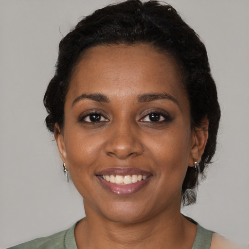 Joyful black young-adult female with short  black hair and brown eyes