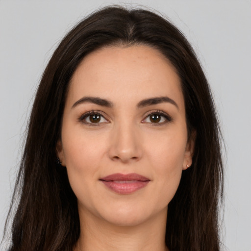 Joyful white young-adult female with long  brown hair and brown eyes