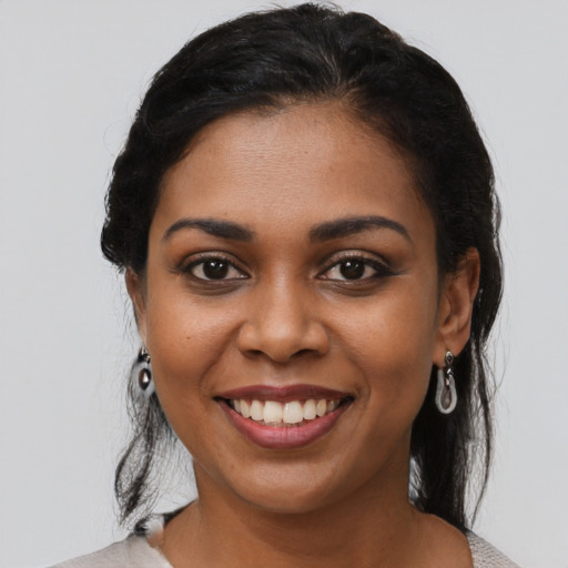 Joyful black young-adult female with medium  black hair and brown eyes
