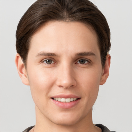 Joyful white young-adult female with short  brown hair and grey eyes