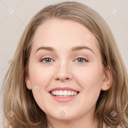 Joyful white young-adult female with long  brown hair and blue eyes