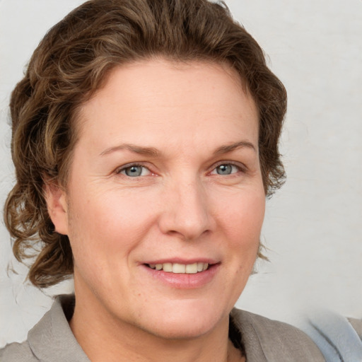 Joyful white adult female with short  brown hair and grey eyes