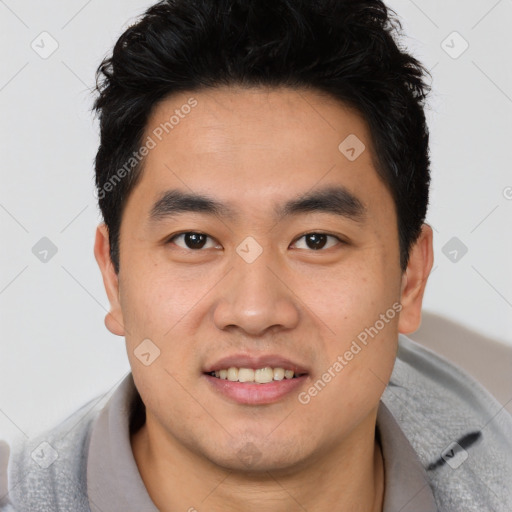 Joyful asian young-adult male with short  brown hair and brown eyes