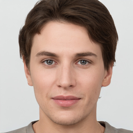 Joyful white young-adult male with short  brown hair and grey eyes