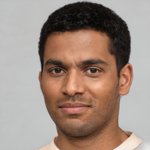 Joyful black young-adult male with short  black hair and brown eyes