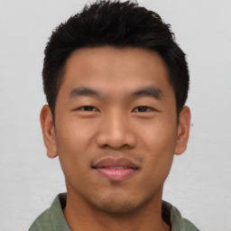 Joyful asian young-adult male with short  black hair and brown eyes