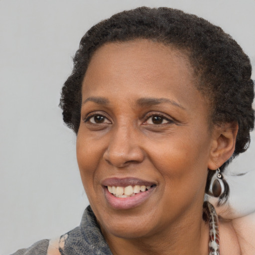 Joyful black adult female with short  brown hair and brown eyes