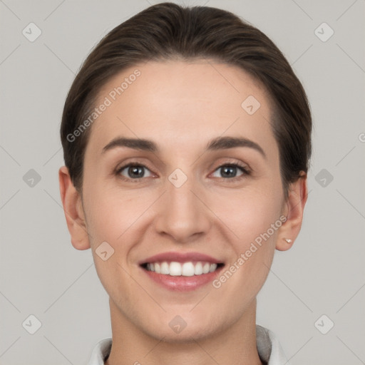 Joyful white young-adult female with short  brown hair and grey eyes