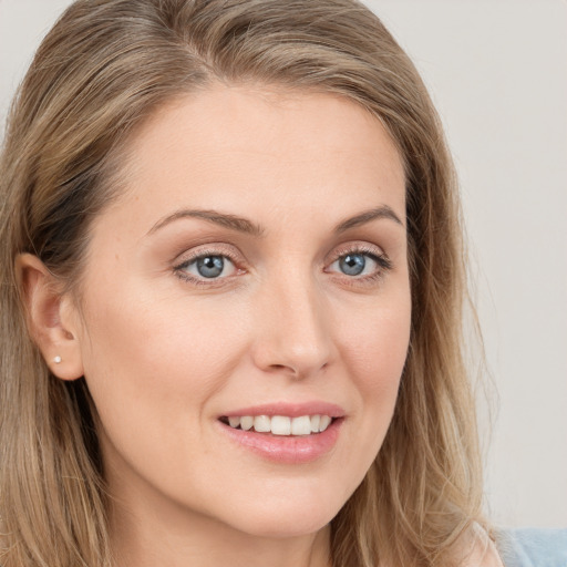 Joyful white young-adult female with long  brown hair and blue eyes