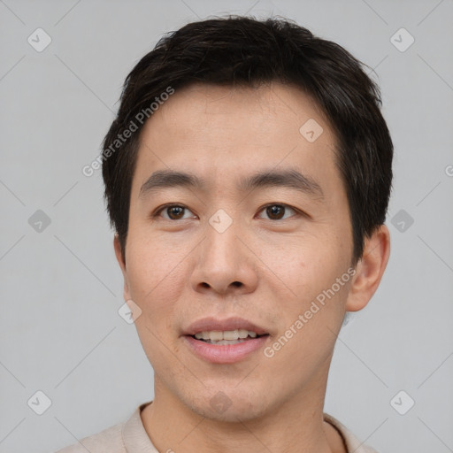 Joyful asian young-adult male with short  brown hair and brown eyes