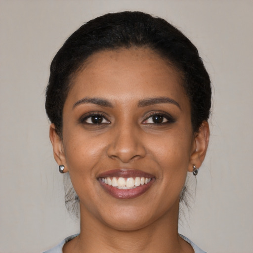 Joyful black young-adult female with short  brown hair and brown eyes