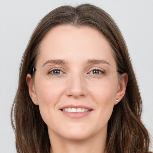 Joyful white young-adult female with long  brown hair and grey eyes