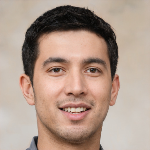 Joyful white young-adult male with short  black hair and brown eyes