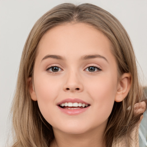 Joyful white child female with long  brown hair and brown eyes