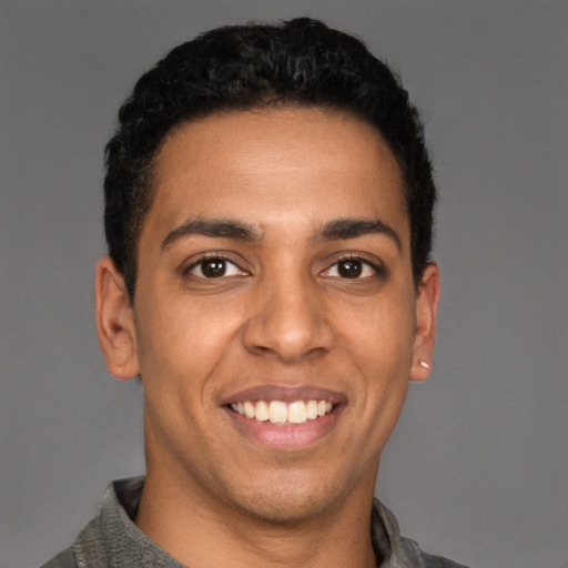 Joyful latino young-adult male with short  black hair and brown eyes